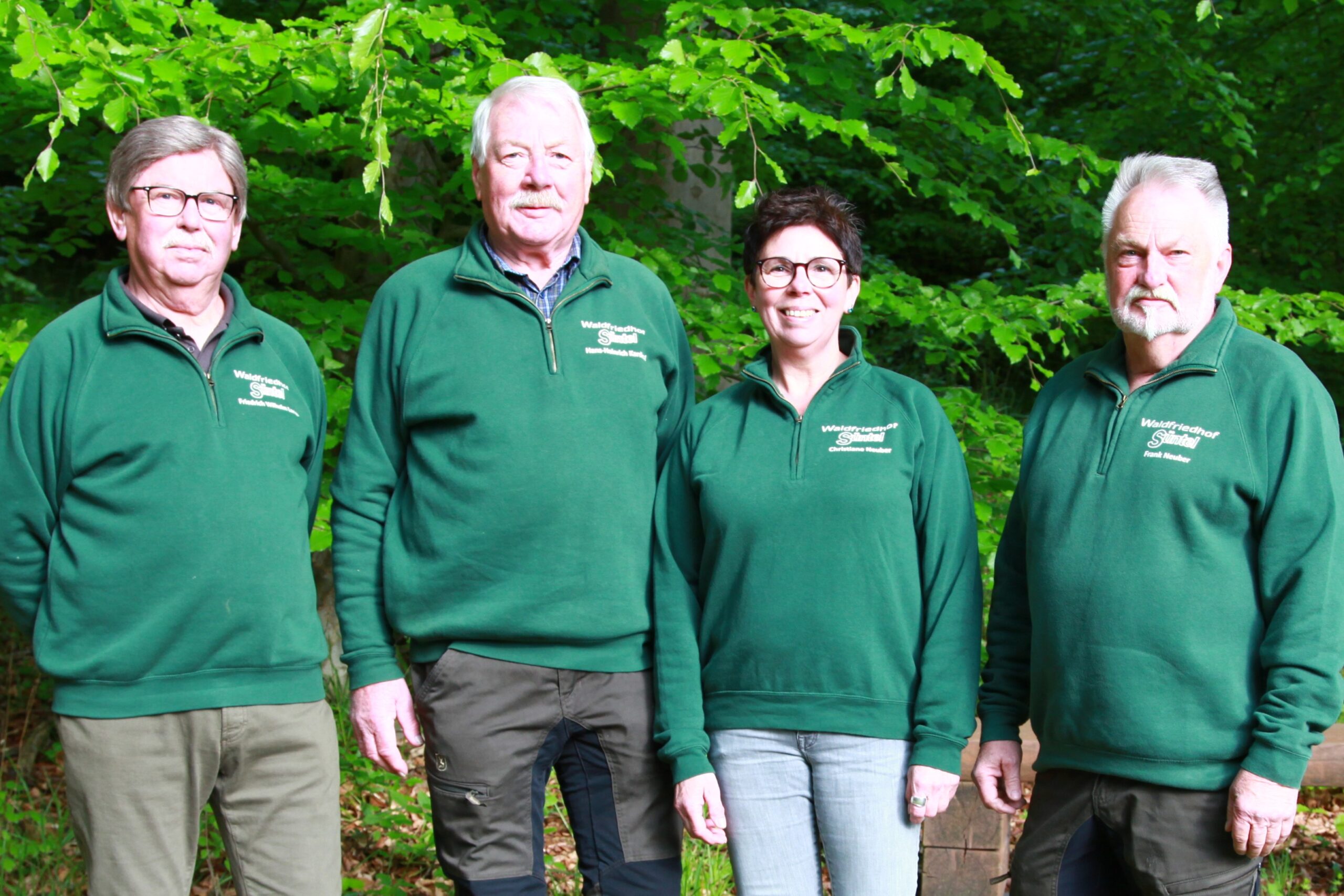 Team Foto der Mitarbeiter des Waldfriedhof Süntel vor einem natürlichen Hintergrund.